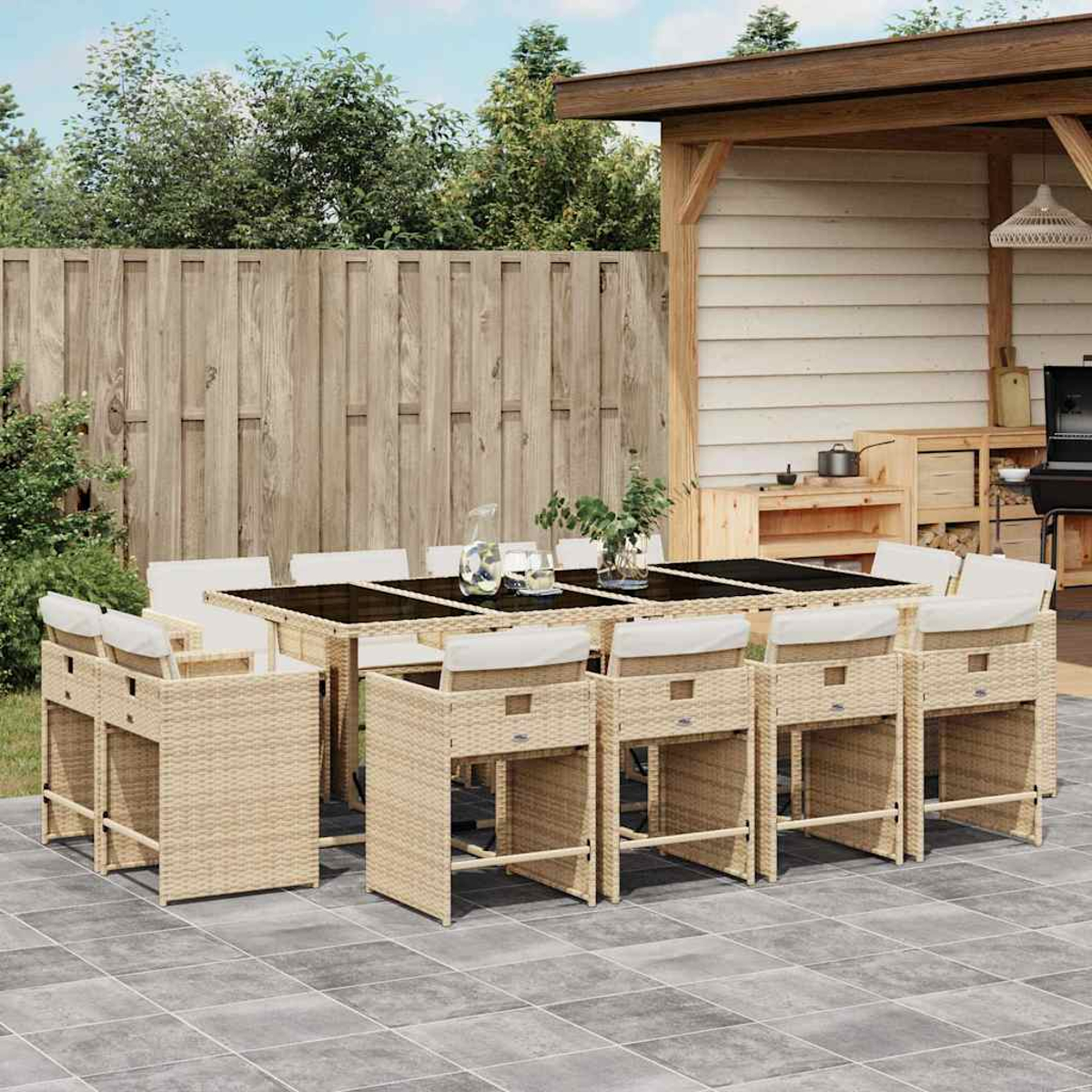 Ein Gartentisch mit Stühlen, daneben ein Grill und eine Außenküche.