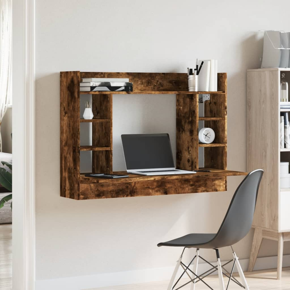 Eine Wandmontage-Schreibtisch-Einheit aus Holz mit Laptop, Büchern und Deko.