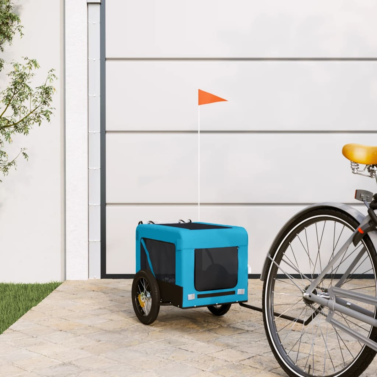 Ein blauer Fahrradanhänger mit orangefarbener Fahne steht neben einem Fahrrad.