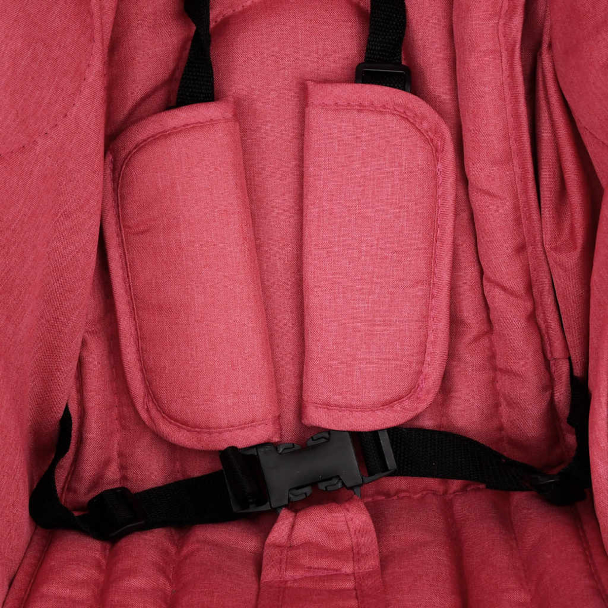 Nahaufnahme eines roten Kinderwagengeschirrs mit Schnalle.