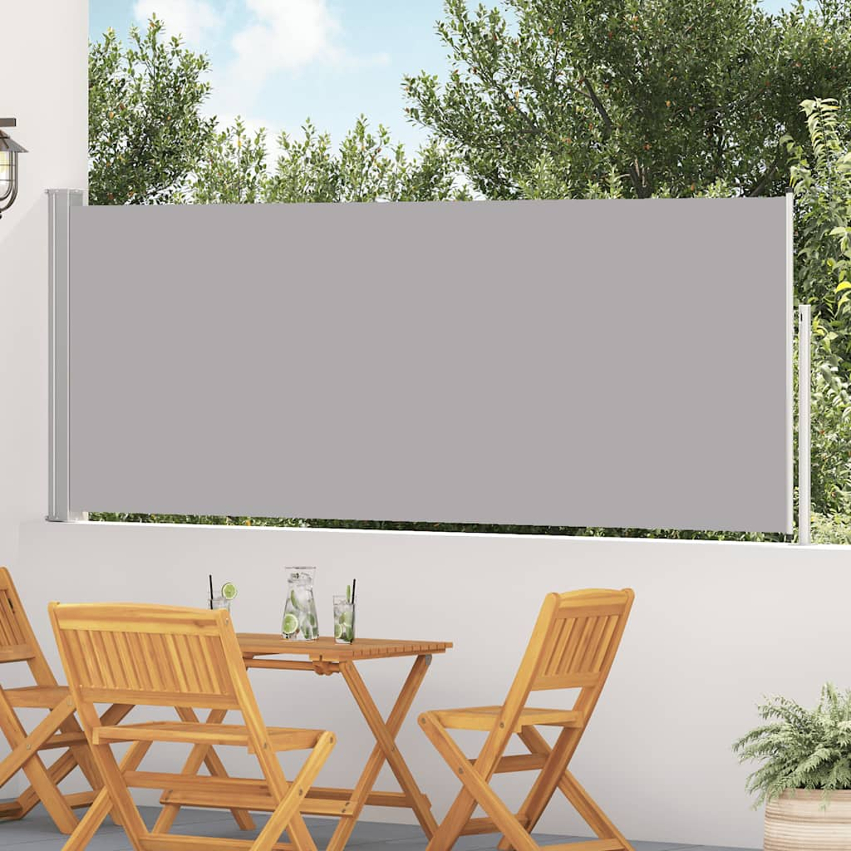 Una tenda da sole retrattile grigia ombreggia un patio con sedie e tavolo in legno.