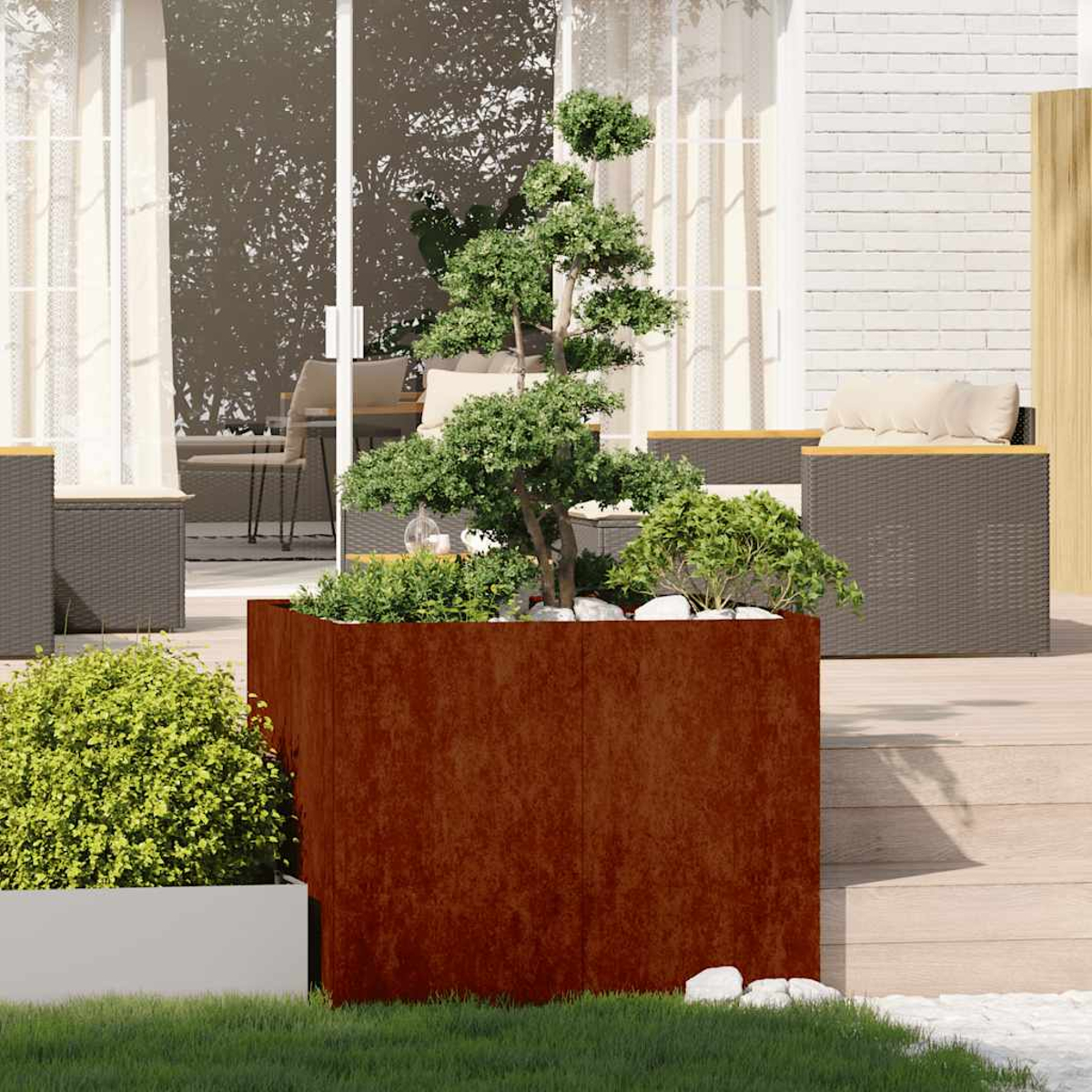 Una fioriera in metallo arrugginito con un bonsai e arbusti su un ponte di legno.