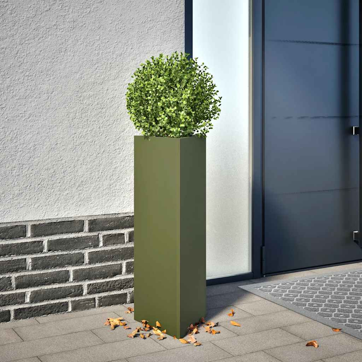 Ein hoher, grüner Pflanzkübel mit einer runden grünen Pflanze auf einer gepflasterten Terrasse.