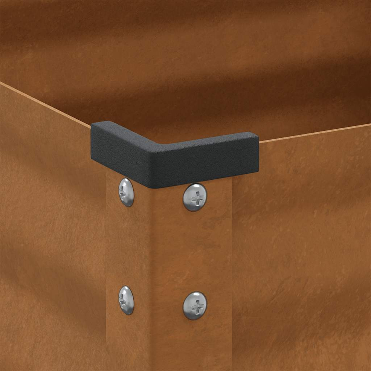Una protezione angolare in plastica nera è fissata a una superficie di legno marrone con quattro viti.