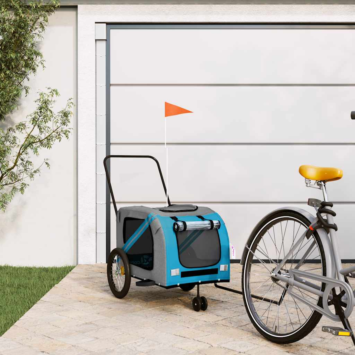 Blauer und grauer Hundeanhänger mit oranger Flagge neben einem Fahrrad.