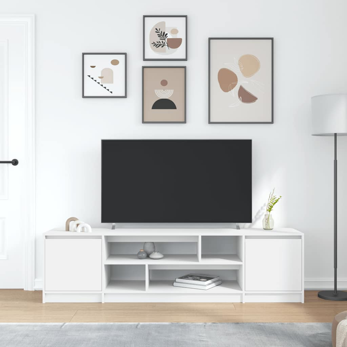 Ein modernes Wohnzimmer mit einem weißen TV-Möbel, einem großen schwarzen Fernseher und abstrakter Kunst.