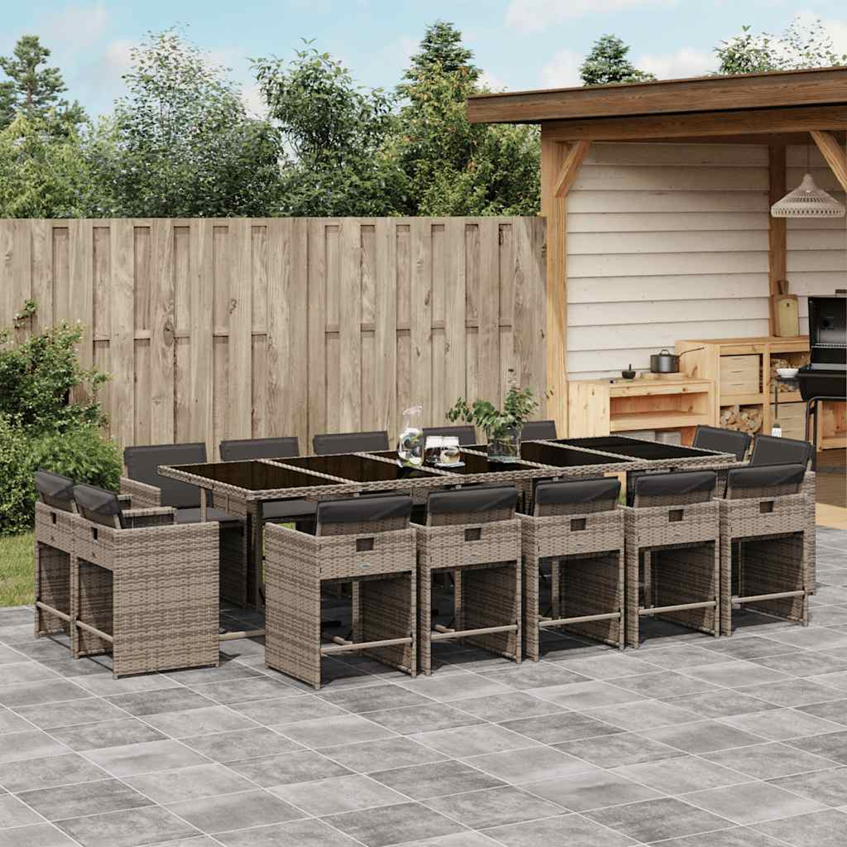 Essgruppe für den Außenbereich mit langem Tisch und hohen Stühlen auf gefliester Terrasse.