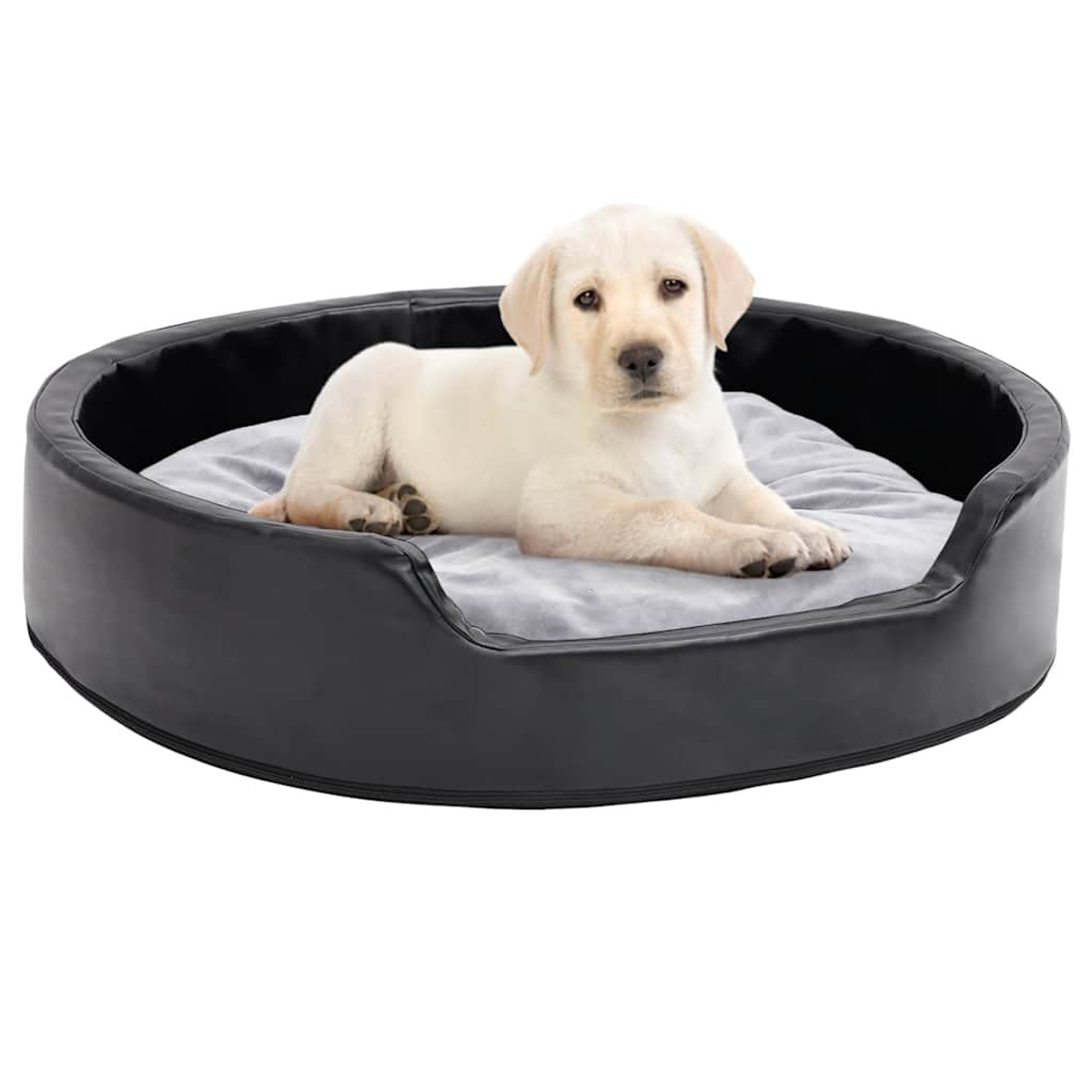 Ein gelber Labrador-Welpe liegt in einem runden schwarzen Hundebett auf einer grauen Decke.