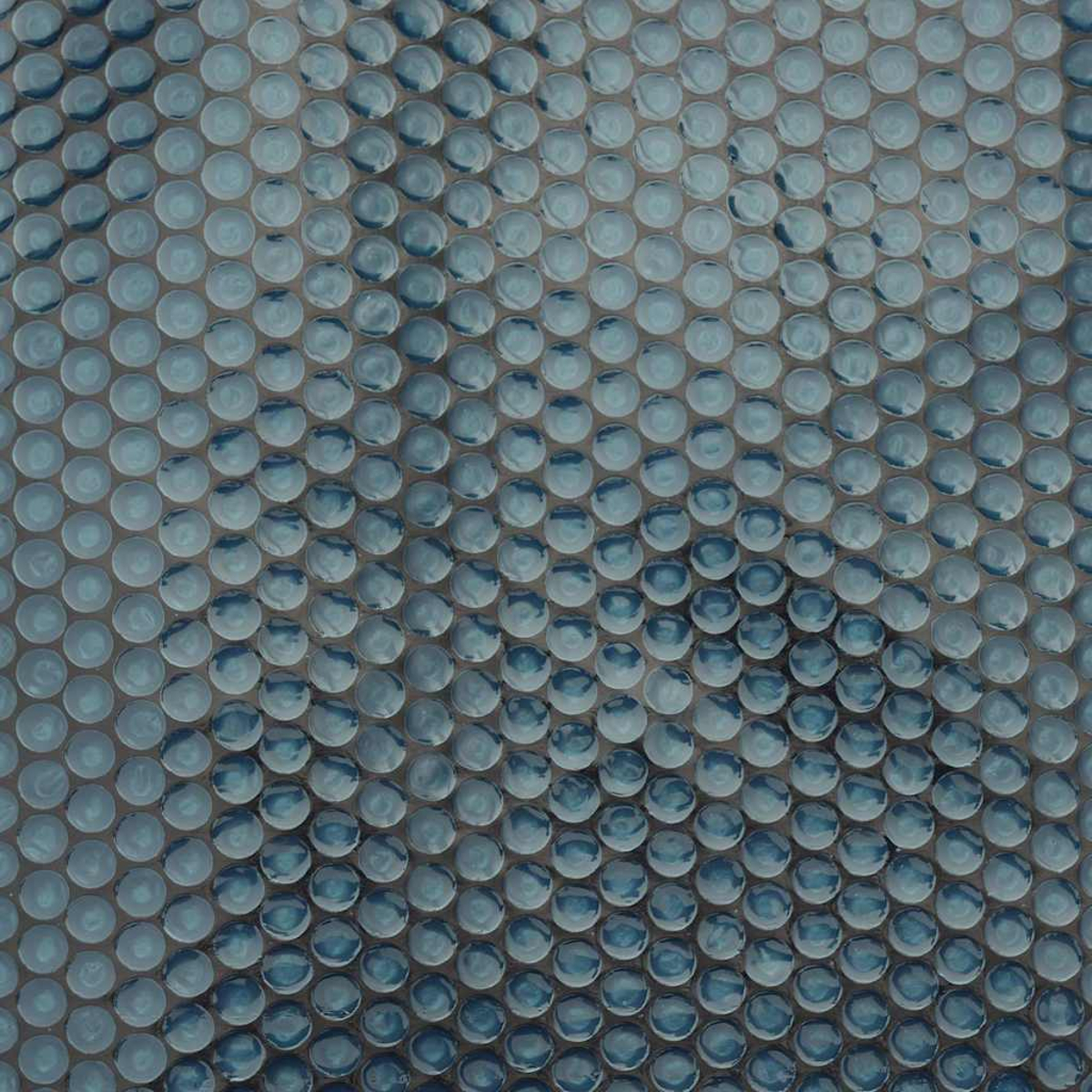 Eine Nahaufnahme von blauen Mosaikfliesen mit einem Blasenmuster.