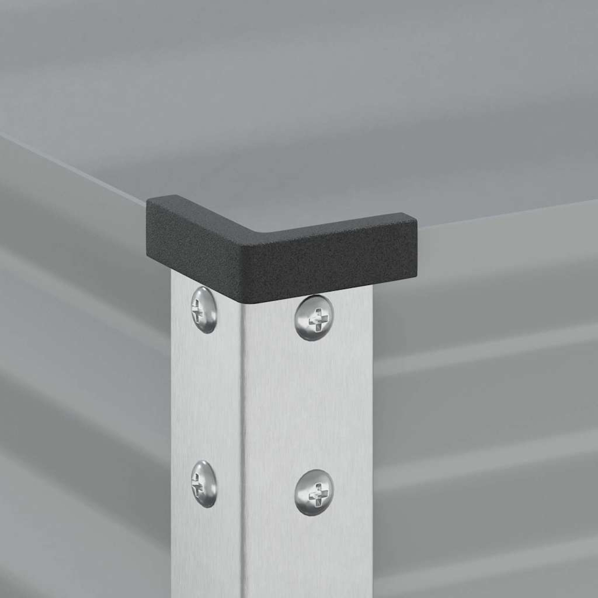 Protezione angolare grigia su palo metallico argentato con viti su sfondo scanalato.