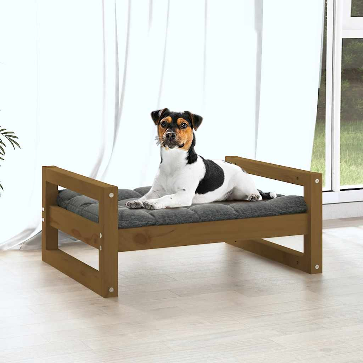 Ein Hund liegt auf einem hölzernen Hundebett mit grauer Polsterung.