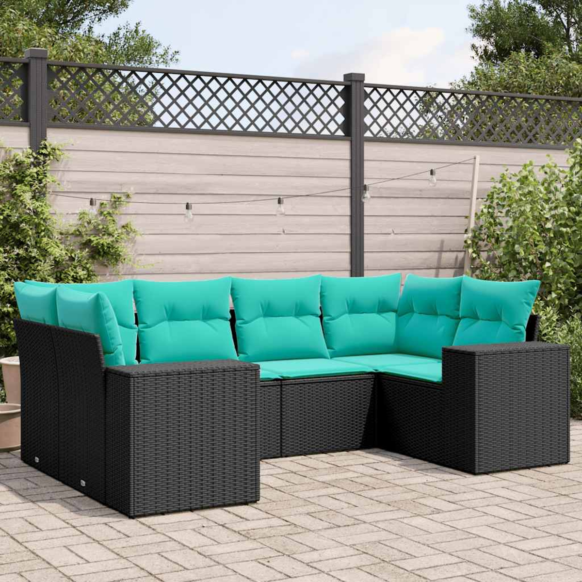 Ein schwarzes Rattan-Ecksofa mit türkisen Polstern auf einer gepflasterten Terrasse.