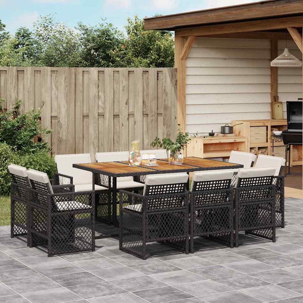 Ein Gartentisch mit Stühlen und einem Grillbereich im Hintergrund.