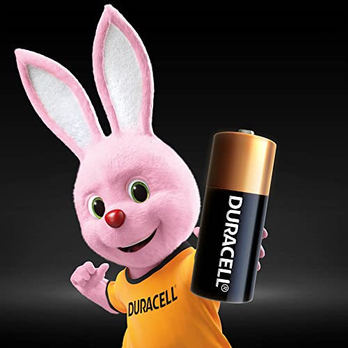 Un conejito mascota de Duracell rosa sostiene una gran batería Duracell.