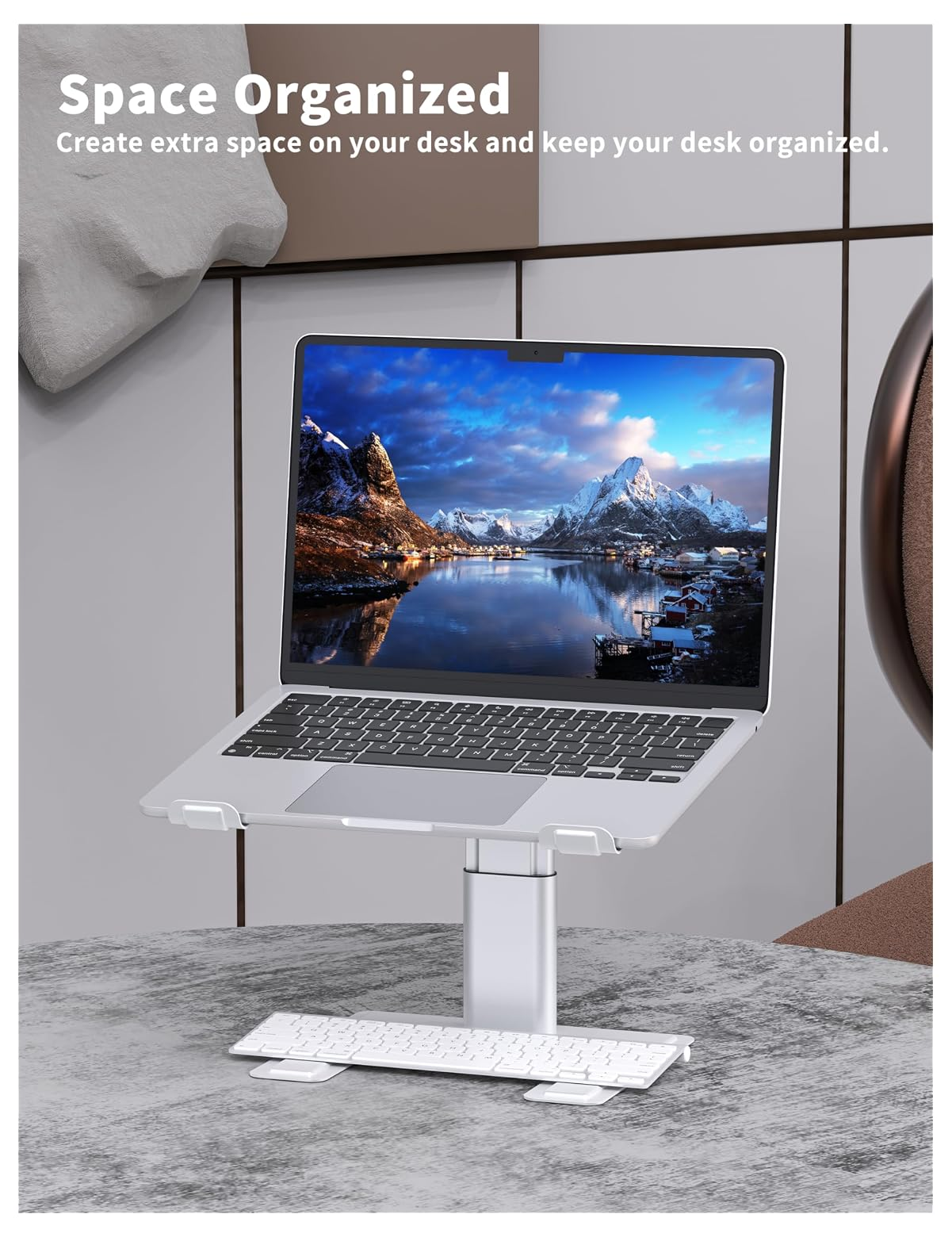 Silberner Laptopständer mit Tastatur auf einem Tisch, der eine malerische Berglandschaft zeigt.