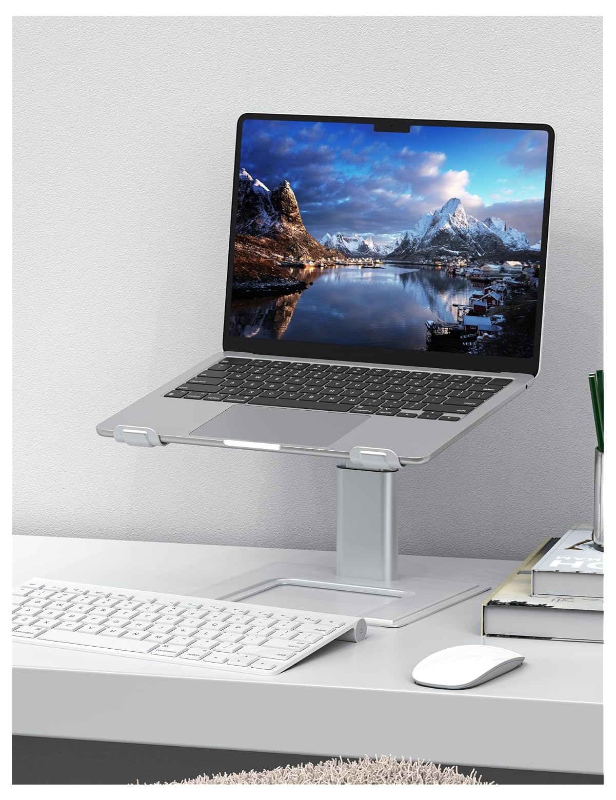 Ein Laptop auf einem Ständer mit Tastatur und Maus daneben.