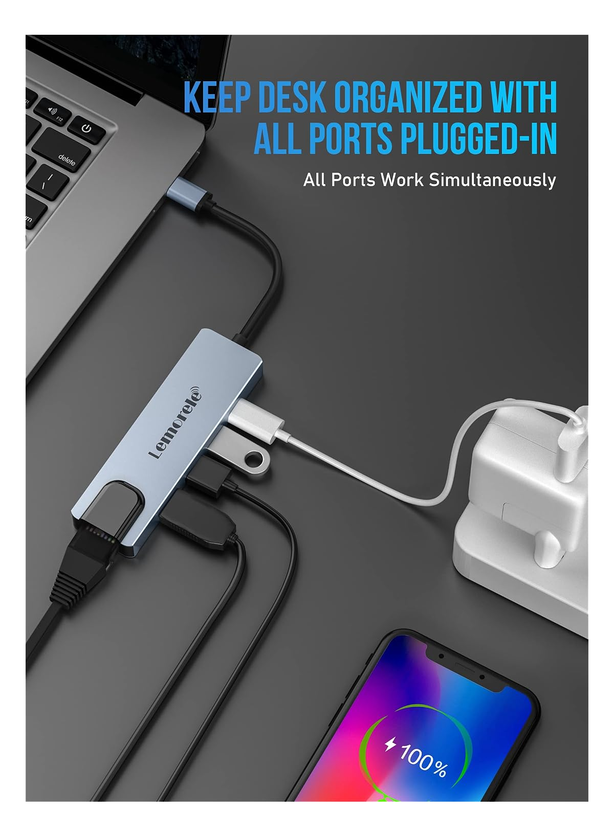 Ein Laptop ist mit einem blauen USB-Hub verbunden, der ein Handy lädt.