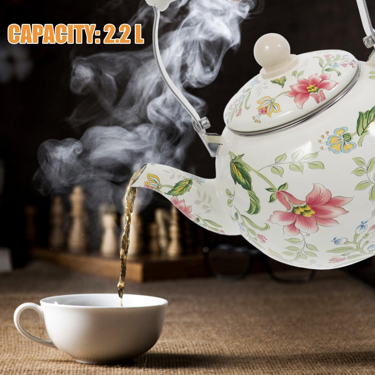 Eine weiße Blumenvase gießt Tee in eine weiße Tasse. Dampf steigt auf.