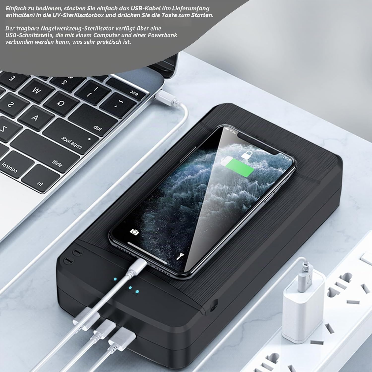 Schwarzer Sterilisator mit Handy und Laptop, lädt über USB.