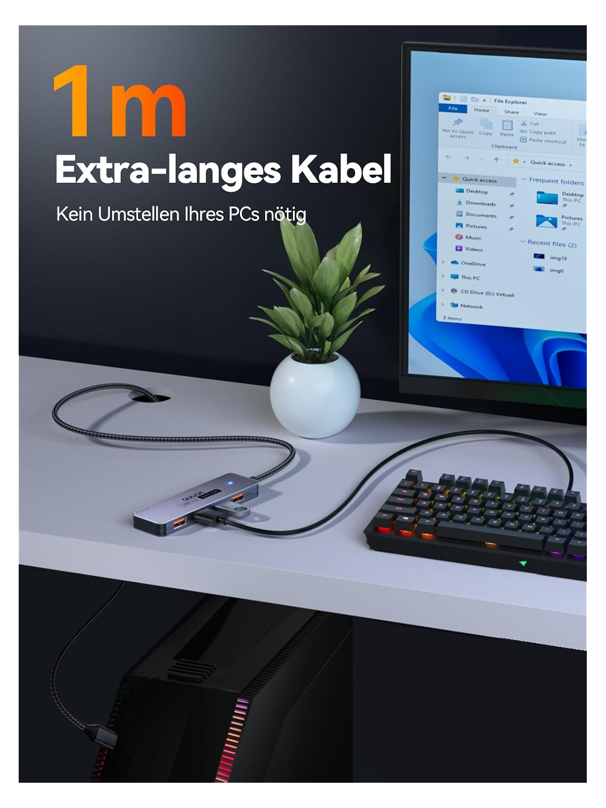 Ein grauer USB-Hub mit angeschlossenen Kabeln, Tastatur und einem PC.