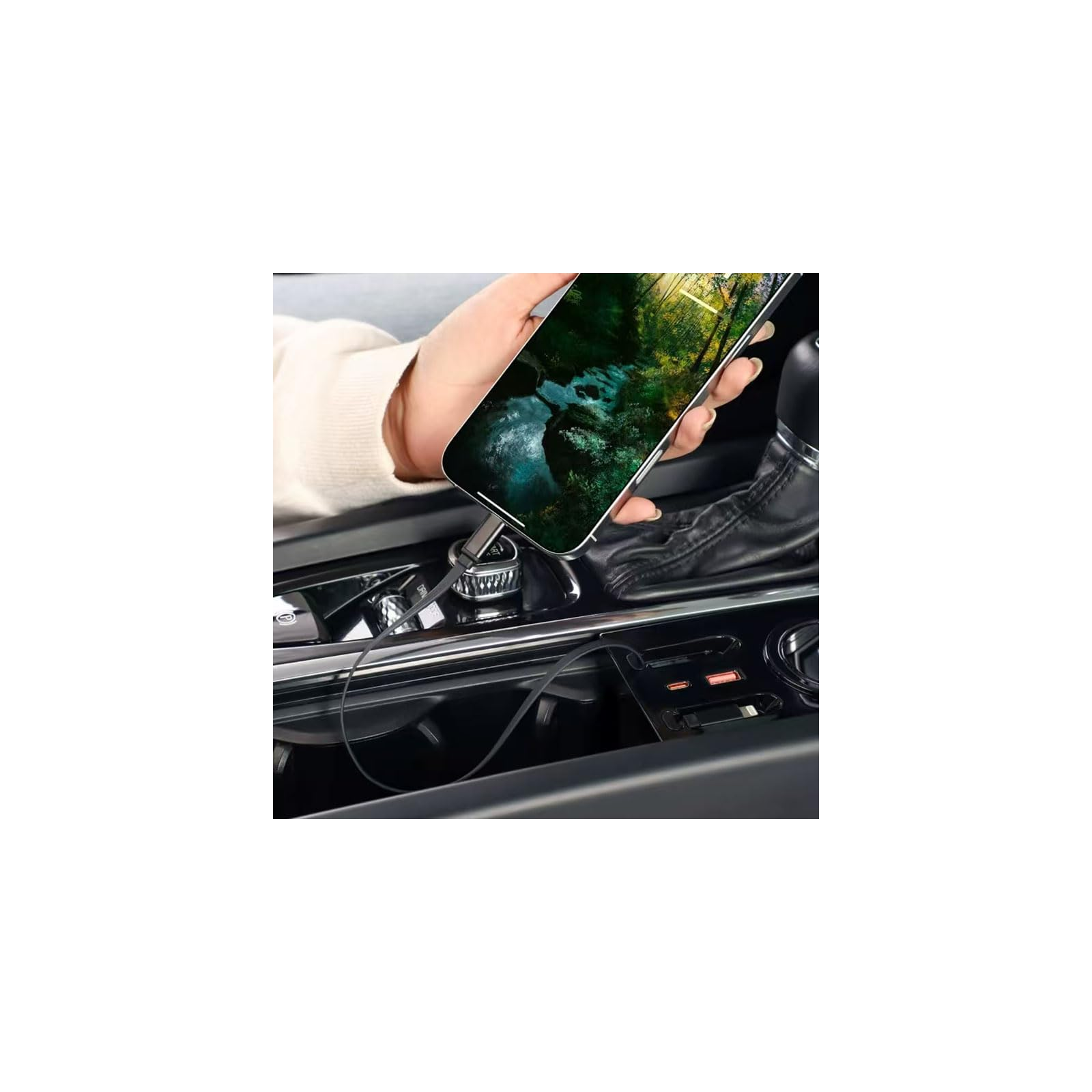 Eine Hand hält ein Handy im Auto, das an ein Ladegerät angeschlossen ist.