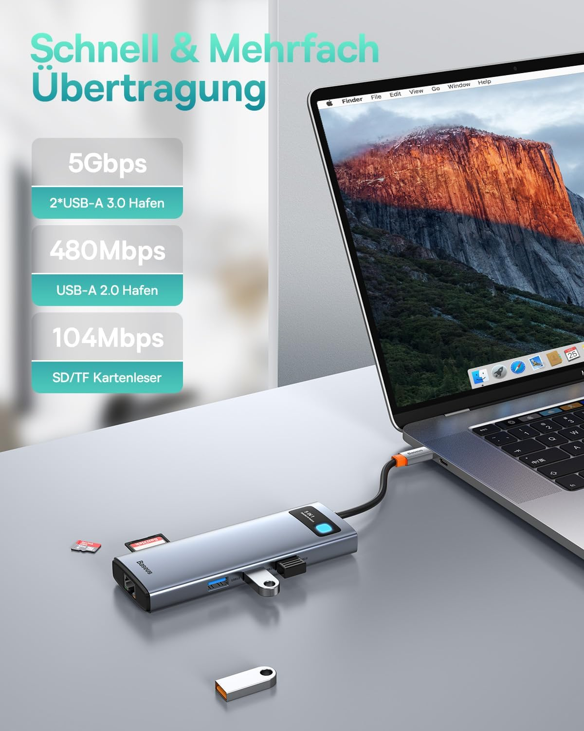 Ein USB-Hub mit SD-Karte und USB-Stick neben einem Laptop, der ein Bergpanorama zeigt.