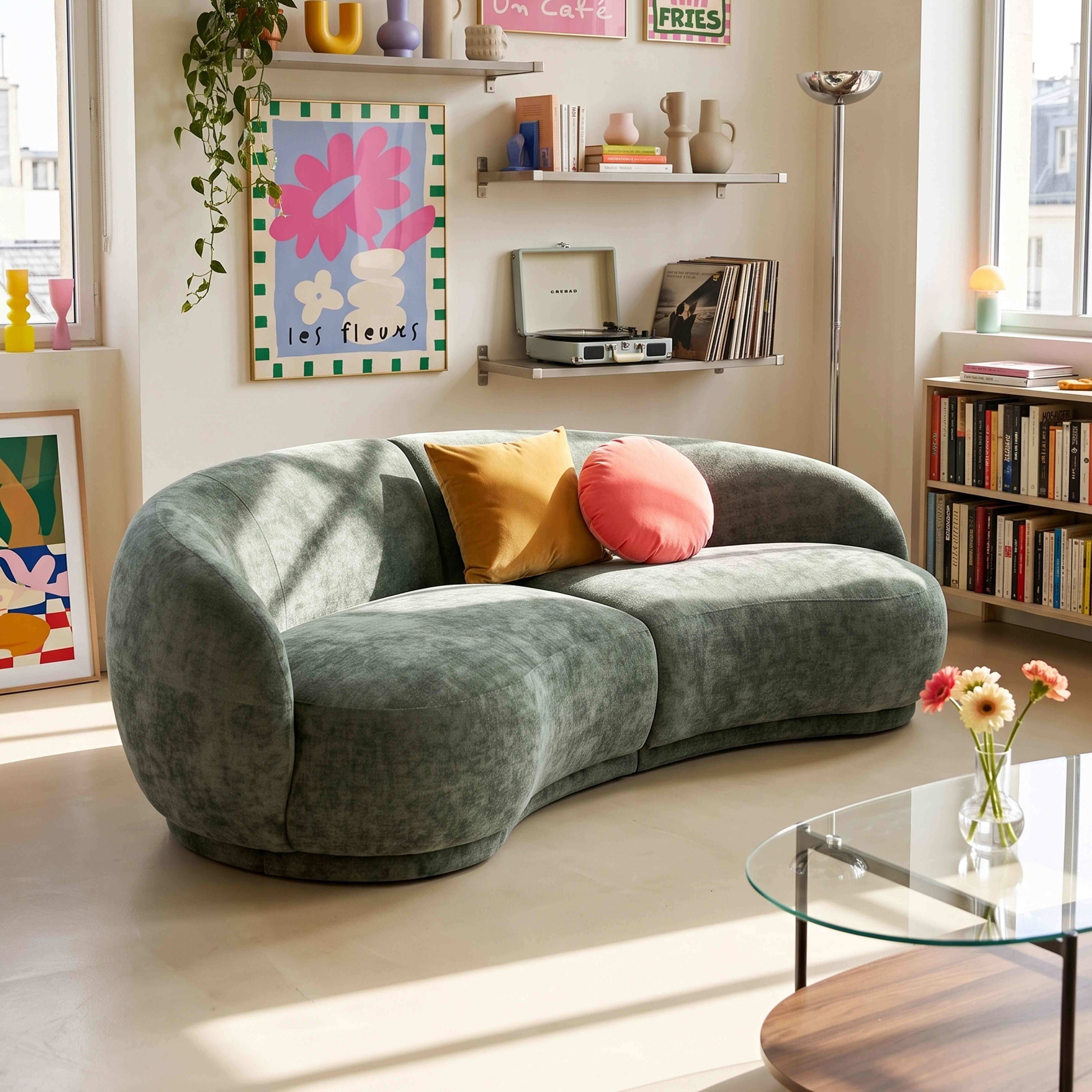 Ein grünes Sofa mit Kissen und Kunst an der Wand.