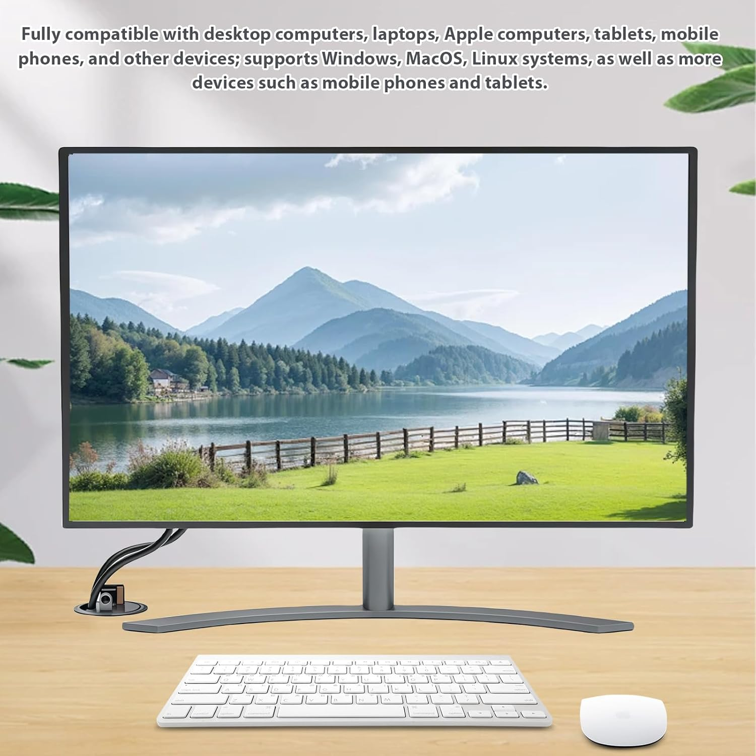 Ein Monitor mit einer Landschaftsszene, Tastatur und Maus auf einem Holzschreibtisch.