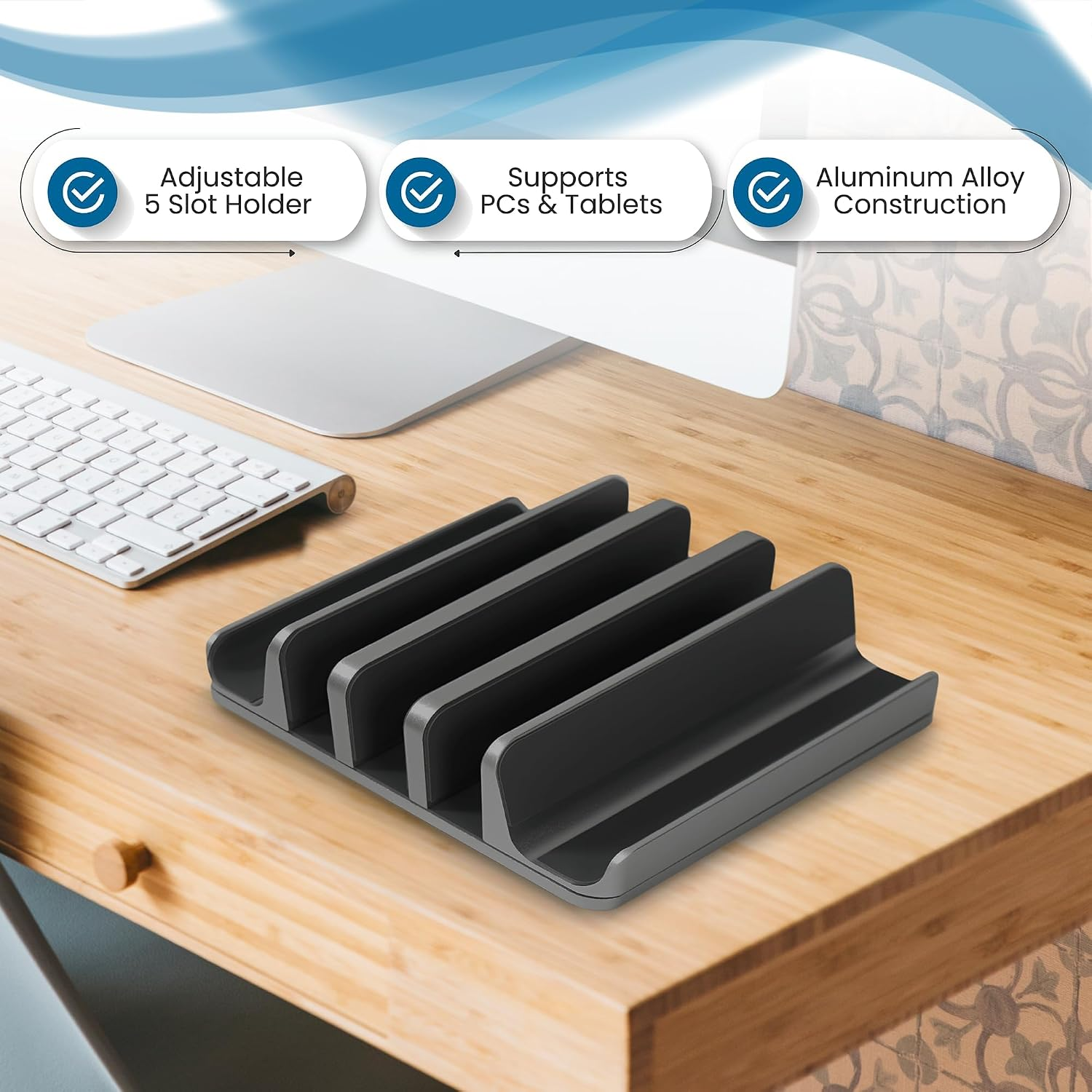 Ein grauer Halter mit 5 Schlitzen für Laptops und Tablets auf einem Schreibtisch.