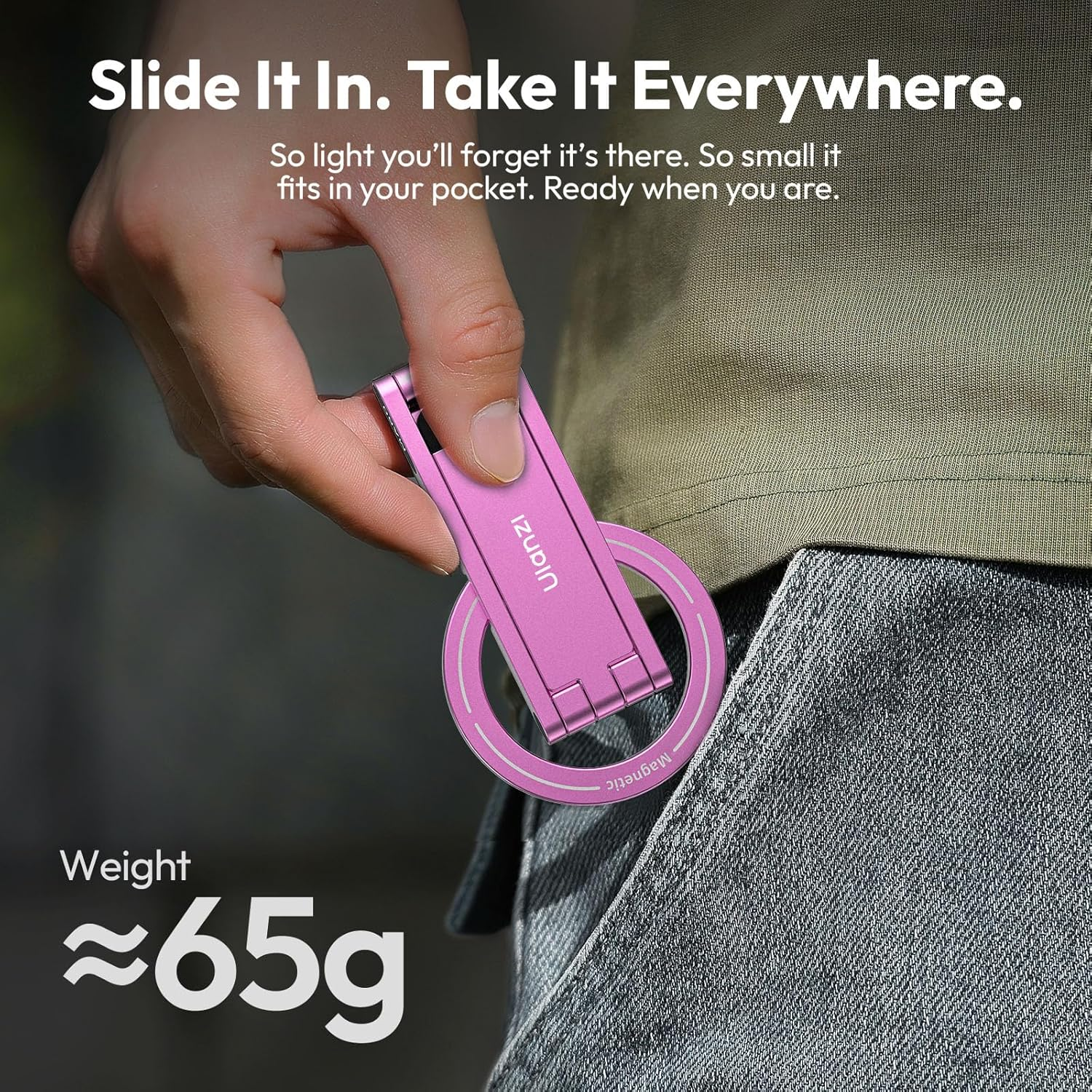 Una mano sostiene un soporte magnético rosa para teléfono que pesa unos 65g.