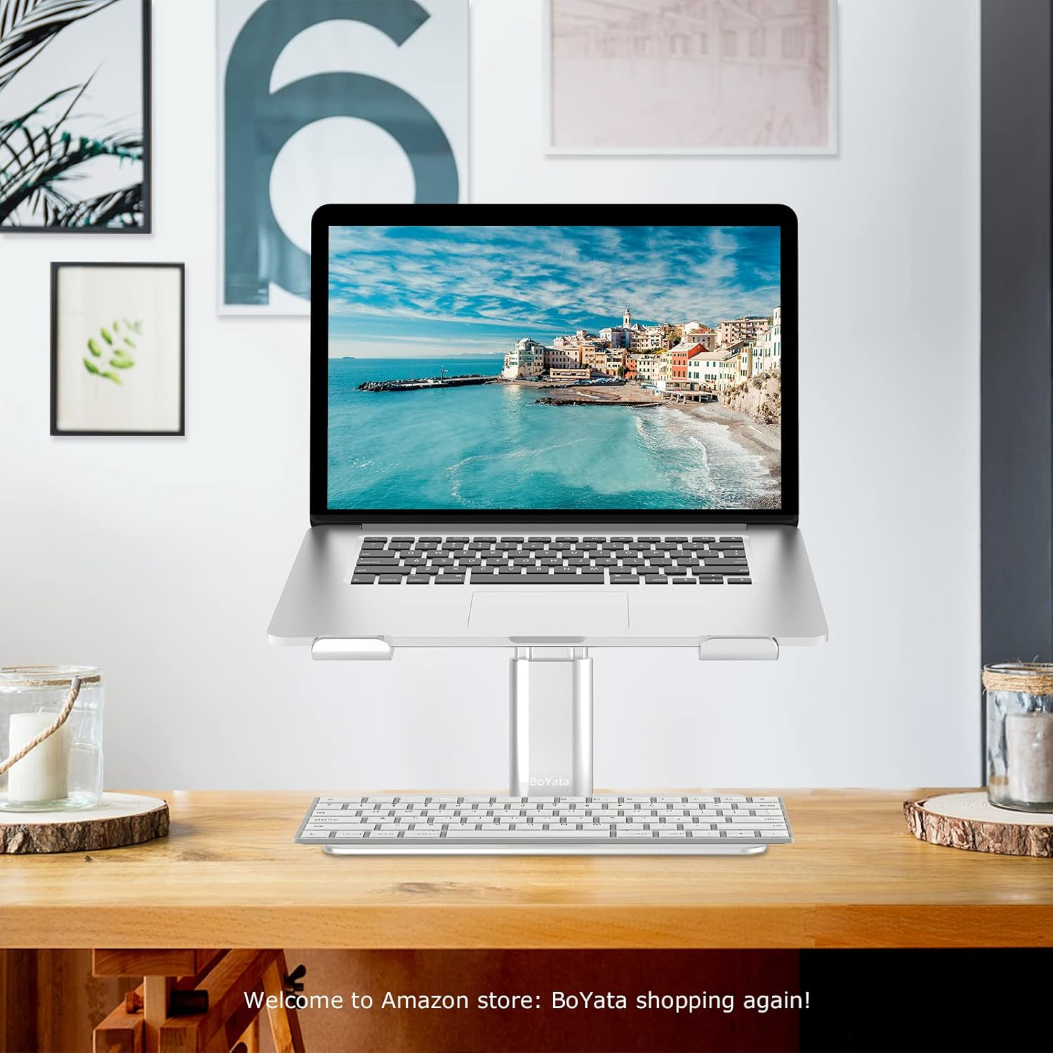 Laptop auf Ständer mit Tastatur auf Schreibtisch. Küstenstadt auf dem Bildschirm.