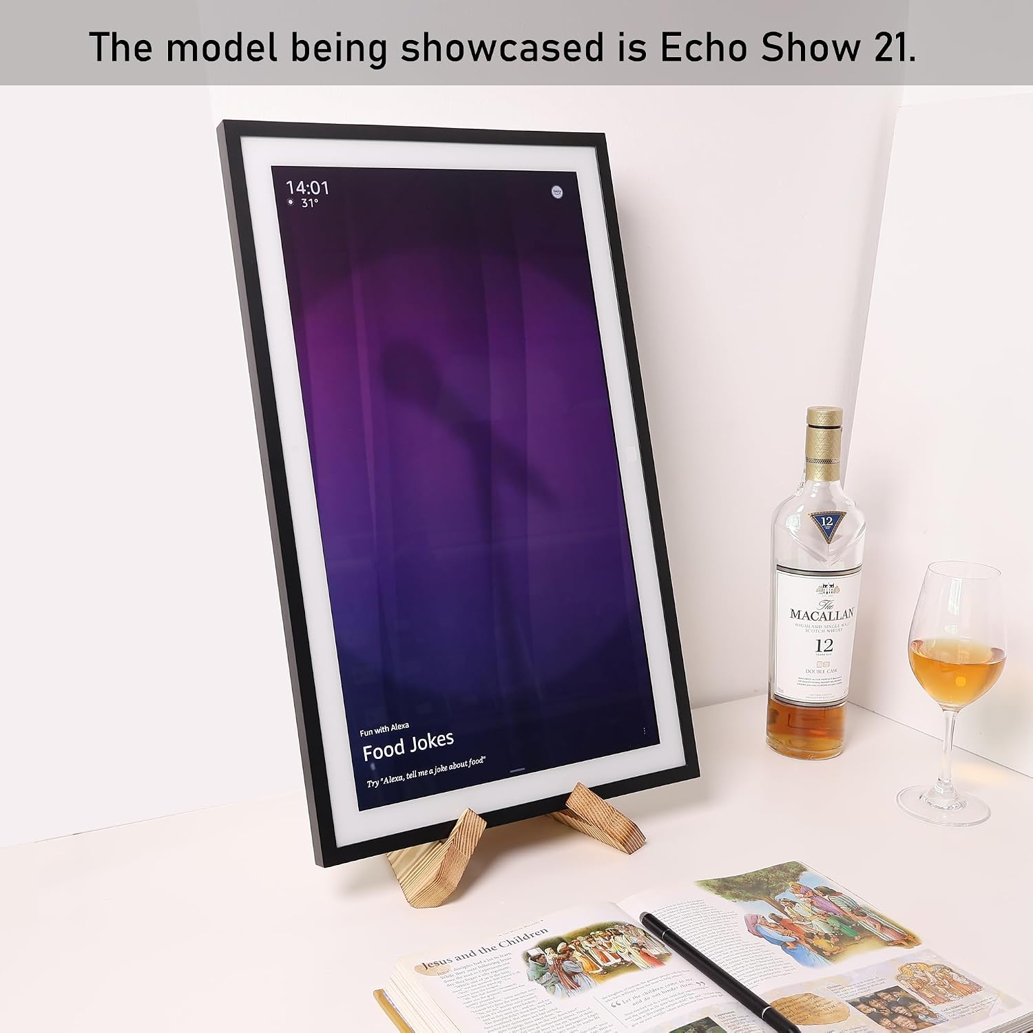 Ein Echo Show 21 steht auf einem Ständer neben einer Whiskyflasche und einem Glas.