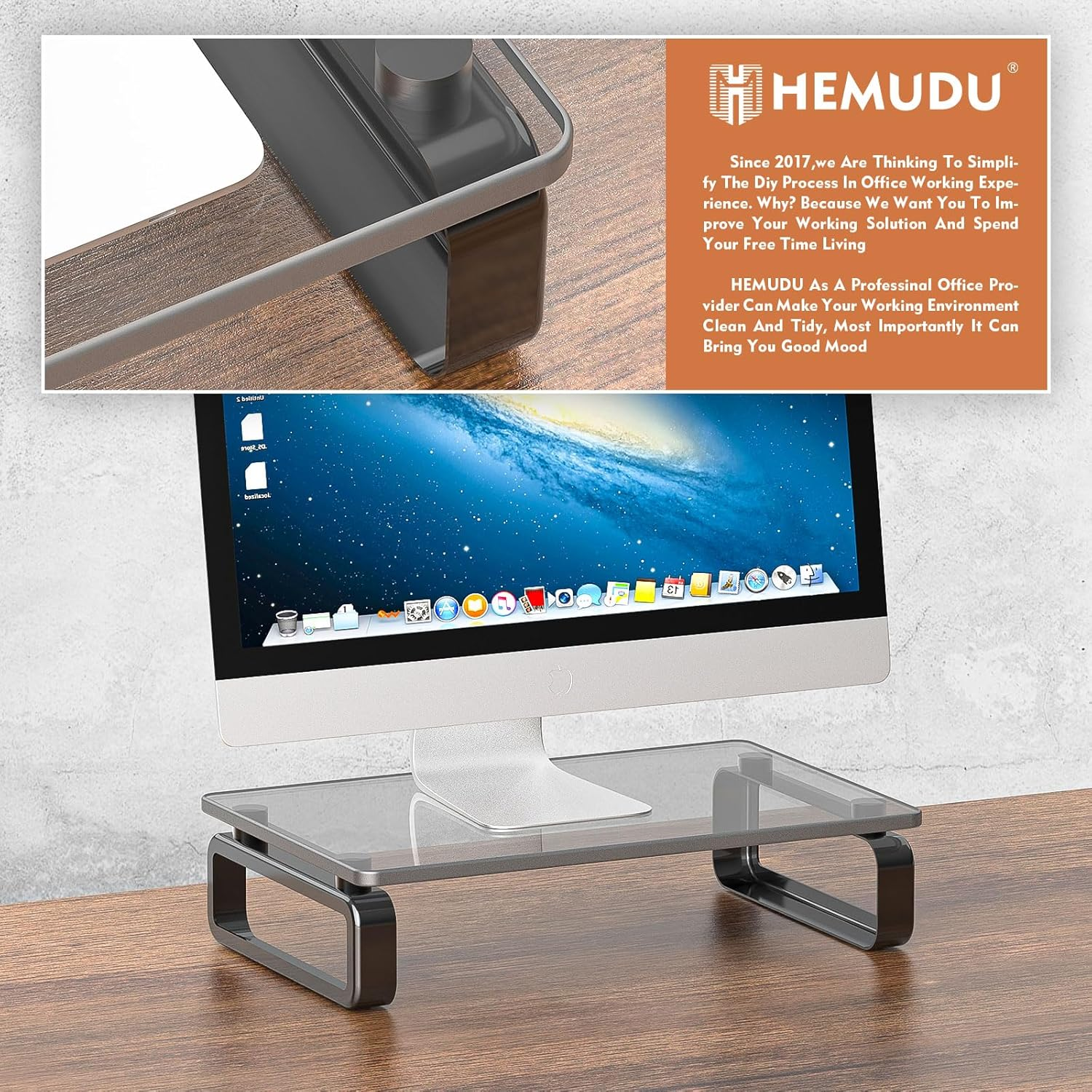 Ein Computermonitor steht auf einem Glasständer auf einem Holztisch.