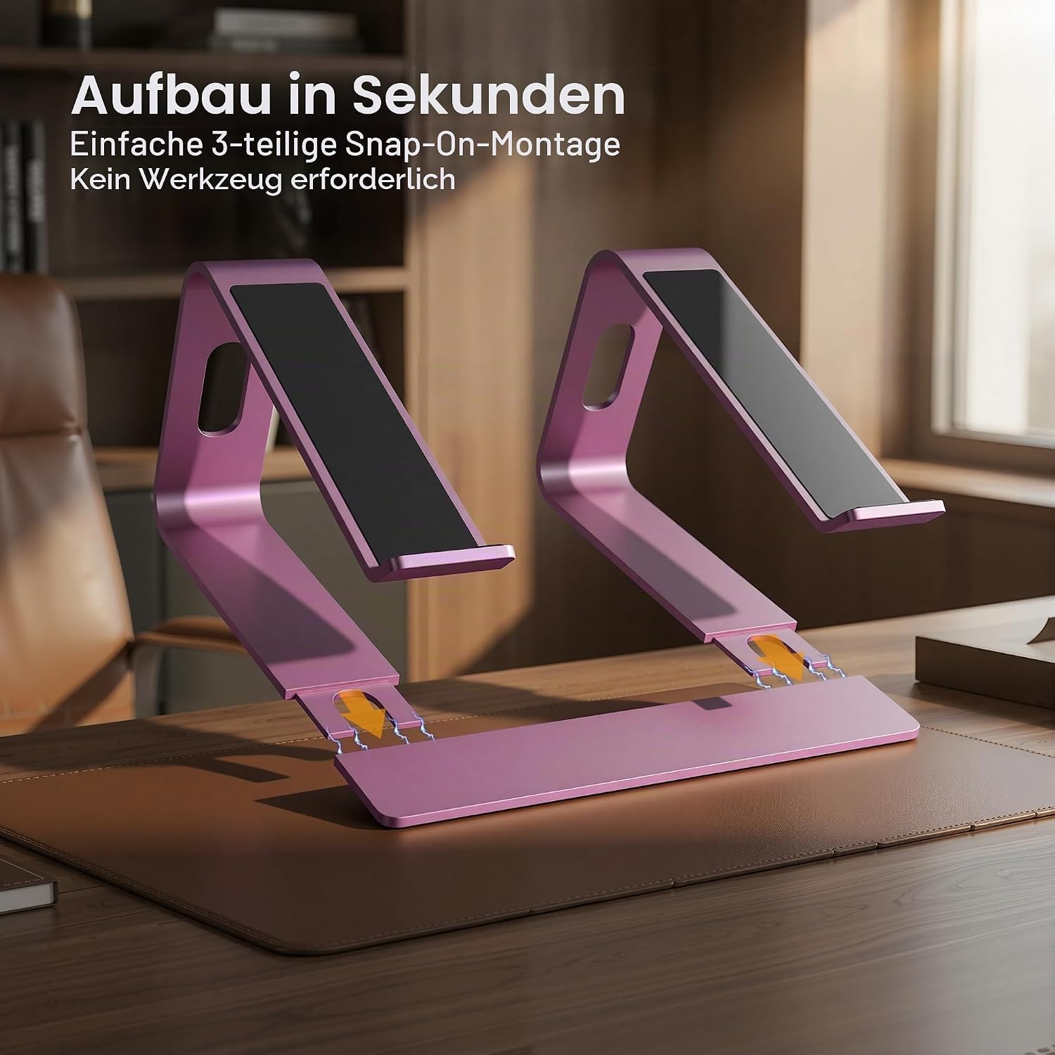 Ein rosafarbener Laptopständer aus Metall auf einem Schreibtisch.