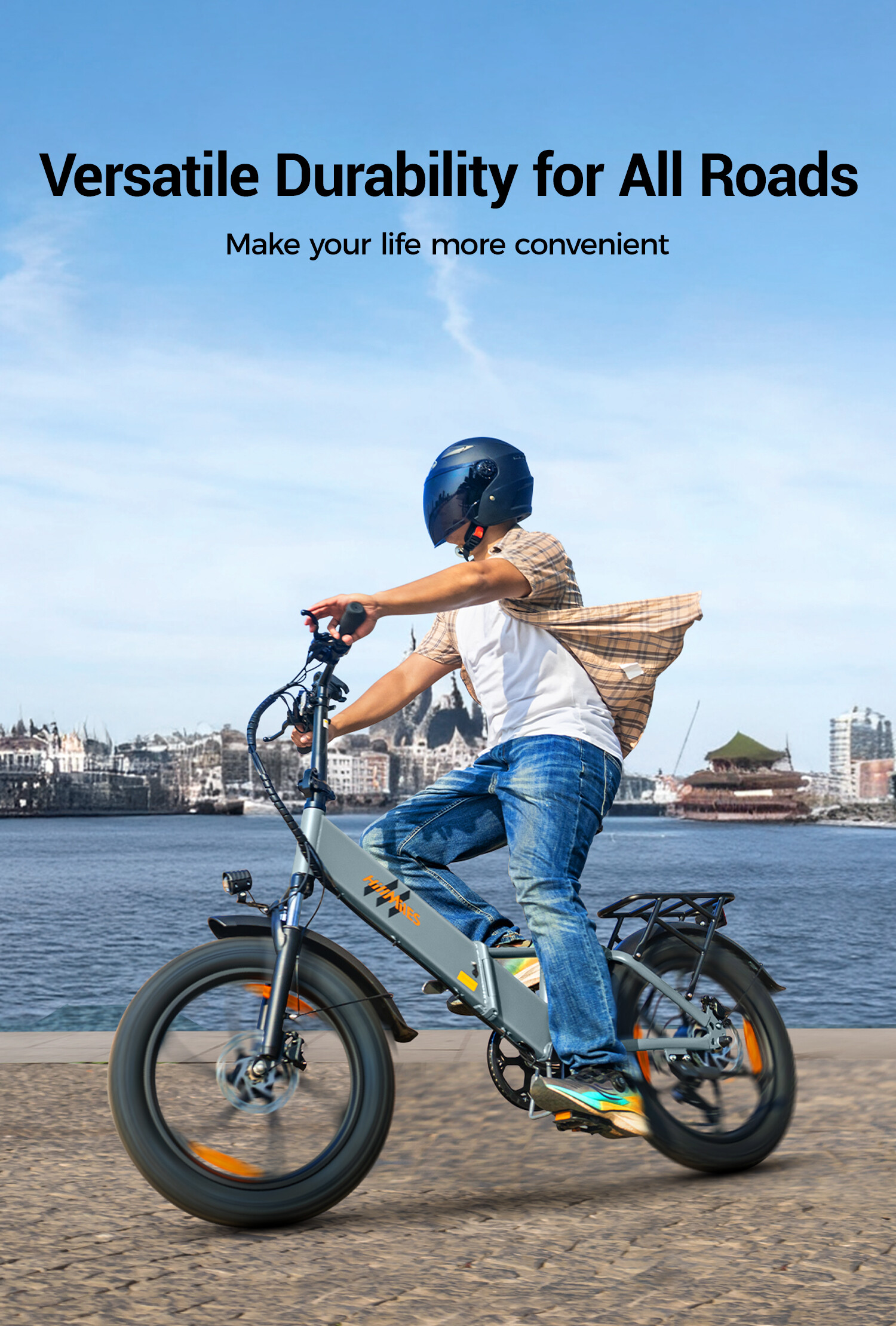 Uomo in e-bike sul lungomare con skyline della città dietro.