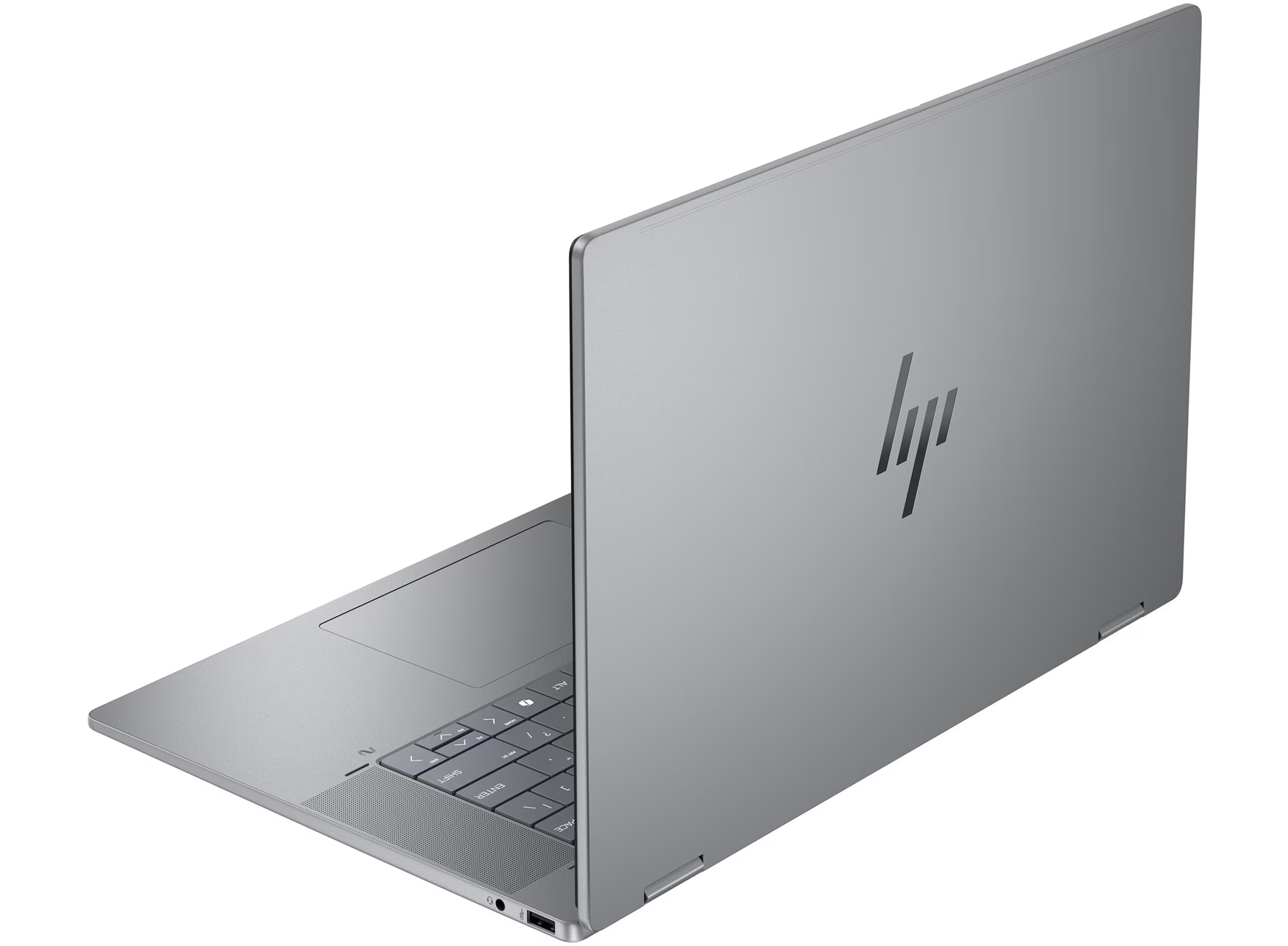 Srebrny laptop HP spoczywa lekko otwarty na białej powierzchni z widocznym logo.