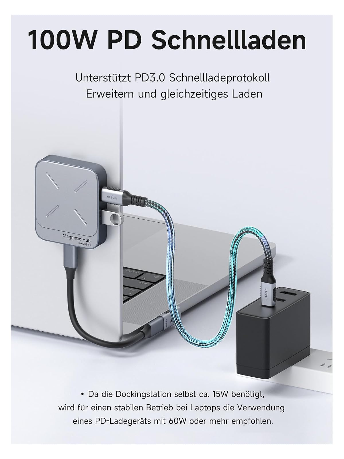 Eine graue Magnet-Dockingstation an einem Laptop angeschlossen, verbunden mit einem schwarzen Ladegerät.