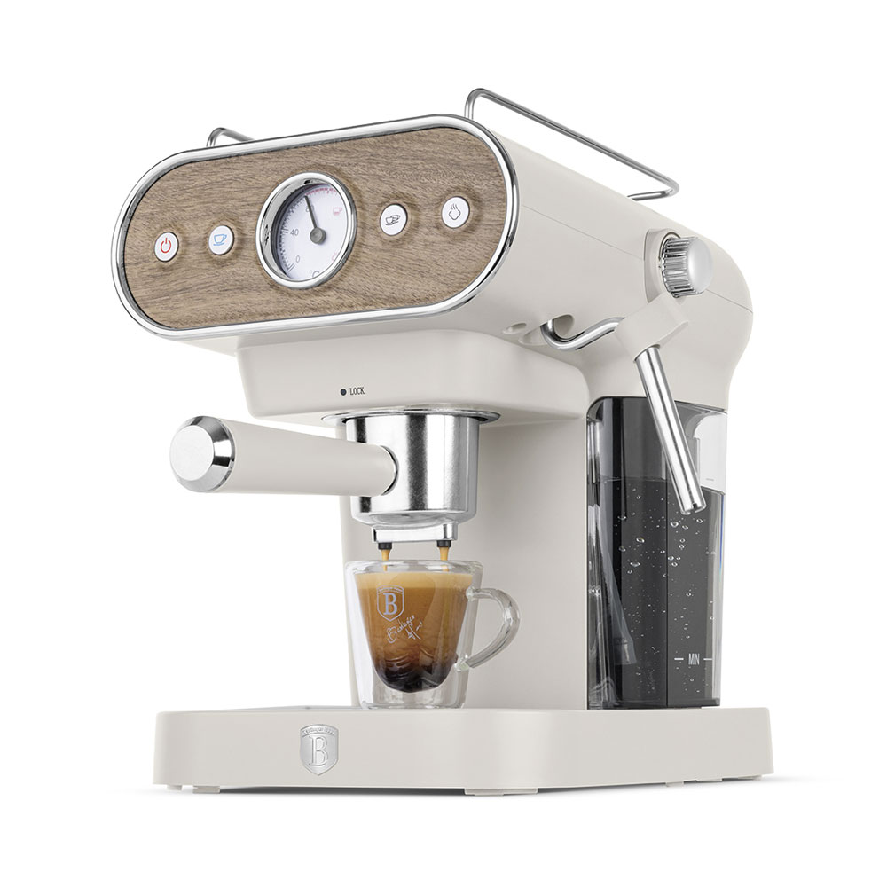 Une machine à espresso crème avec bois et manomètre verse du café dans une tasse en verre.