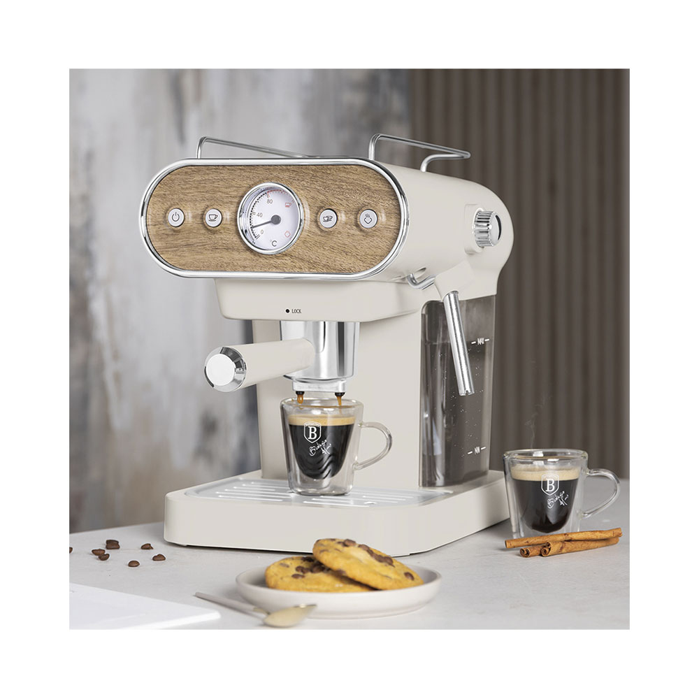 Une machine à expresso crème avec panneau bois verse du café dans une tasse. Des biscuits et de la cannelle à côté.