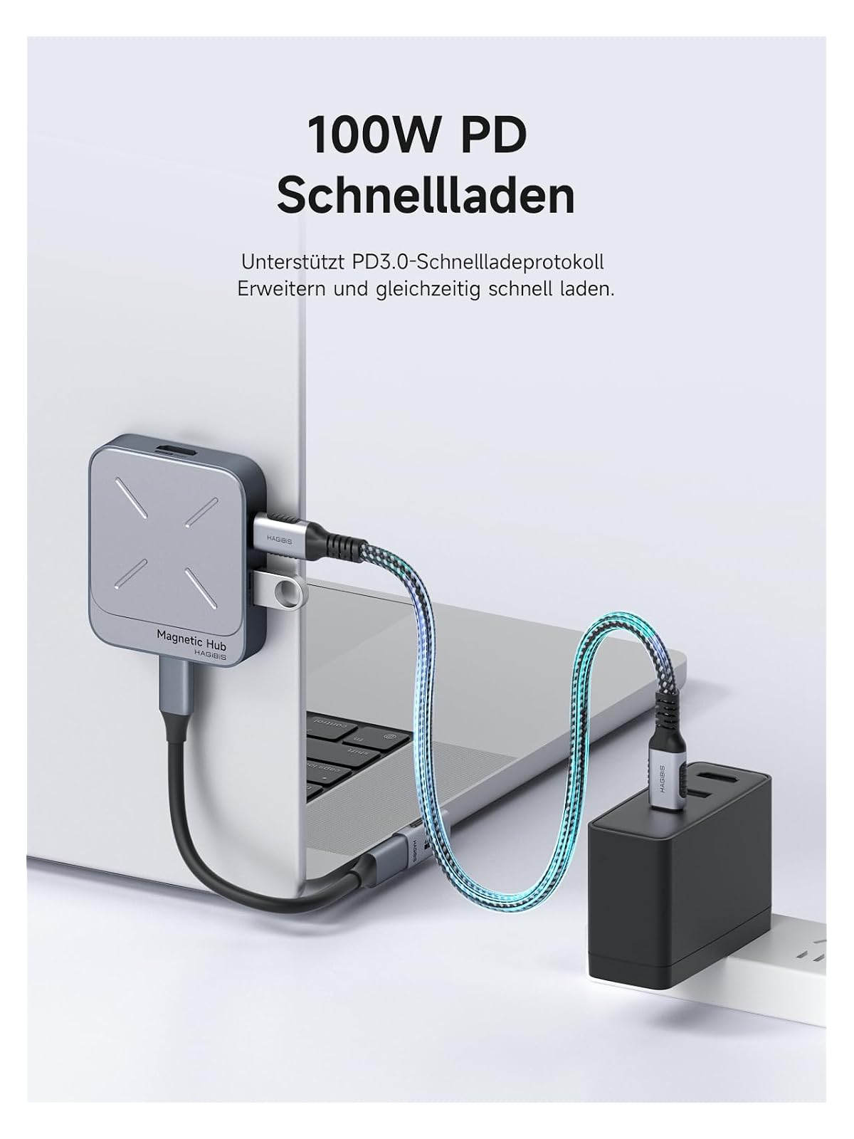 Ein silberner Magnet-Hub ist mit einem Laptop und einem schwarzen Ladegerät über ein blaues Kabel verbunden.