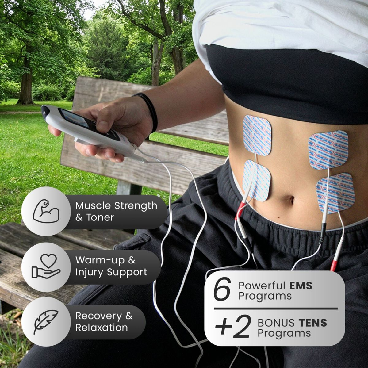 Eine Person auf einer Parkbank nutzt draußen ein TENS-Gerät mit Elektrodenpads auf dem Bauch.