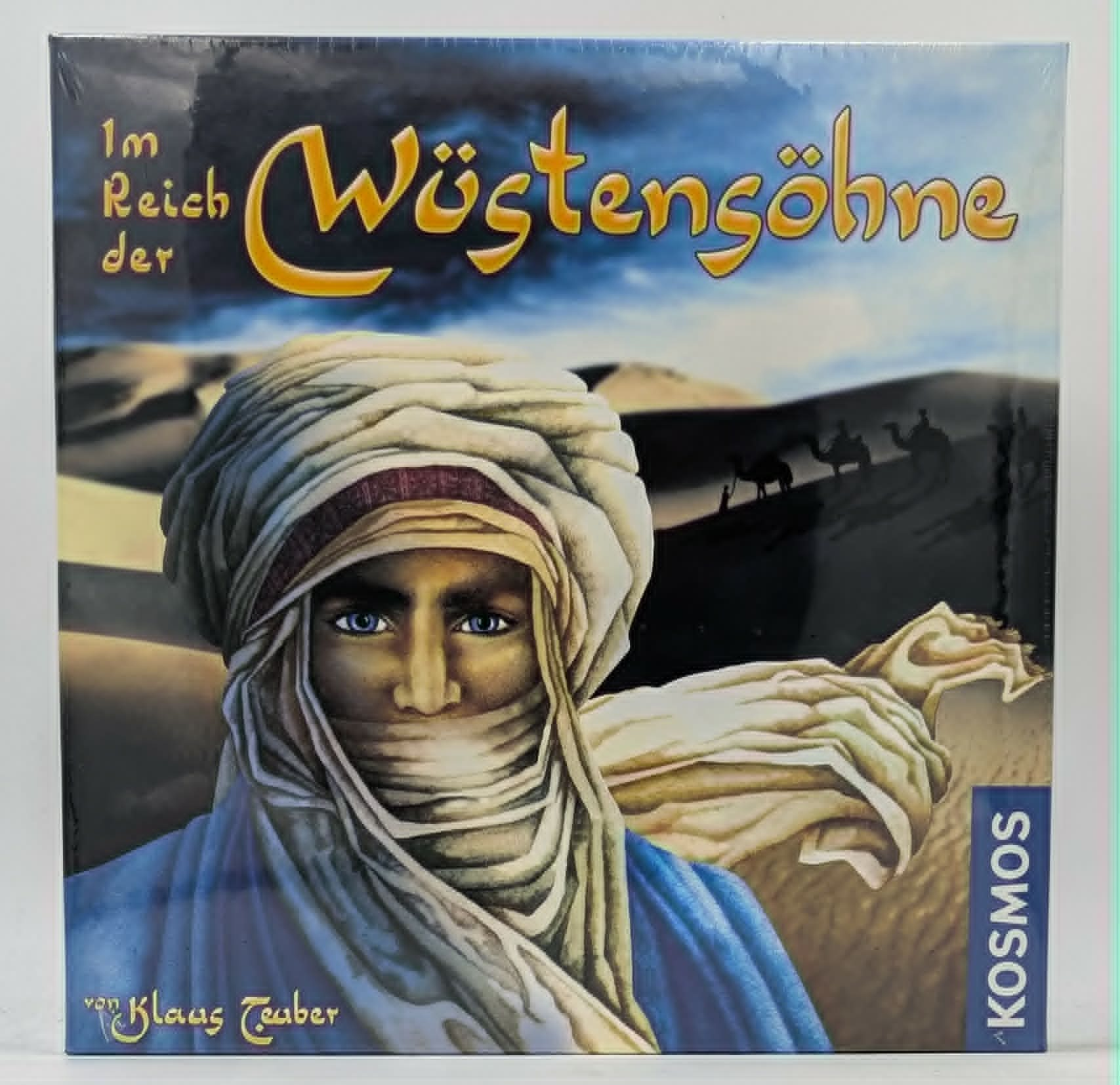 Brettspiel-Cover zeigt einen Mann mit Turban in der Wüste und den Titel Im Reich der Wüstensöhne.