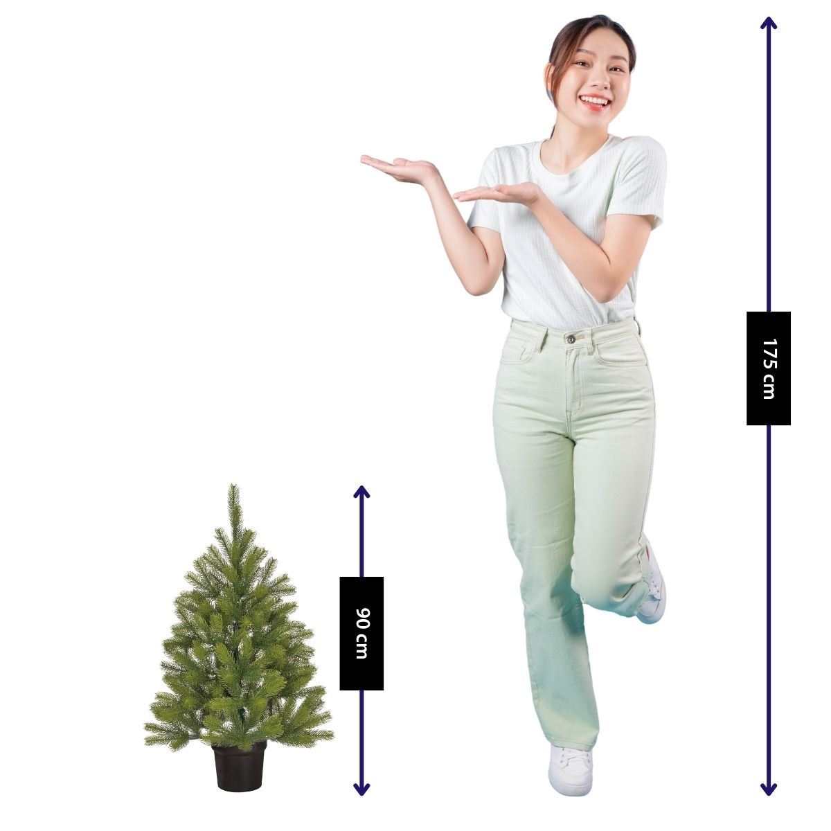 A woman in light clothes gestures towards a 90 cm small Christmas tree compared to her 175 cm height.