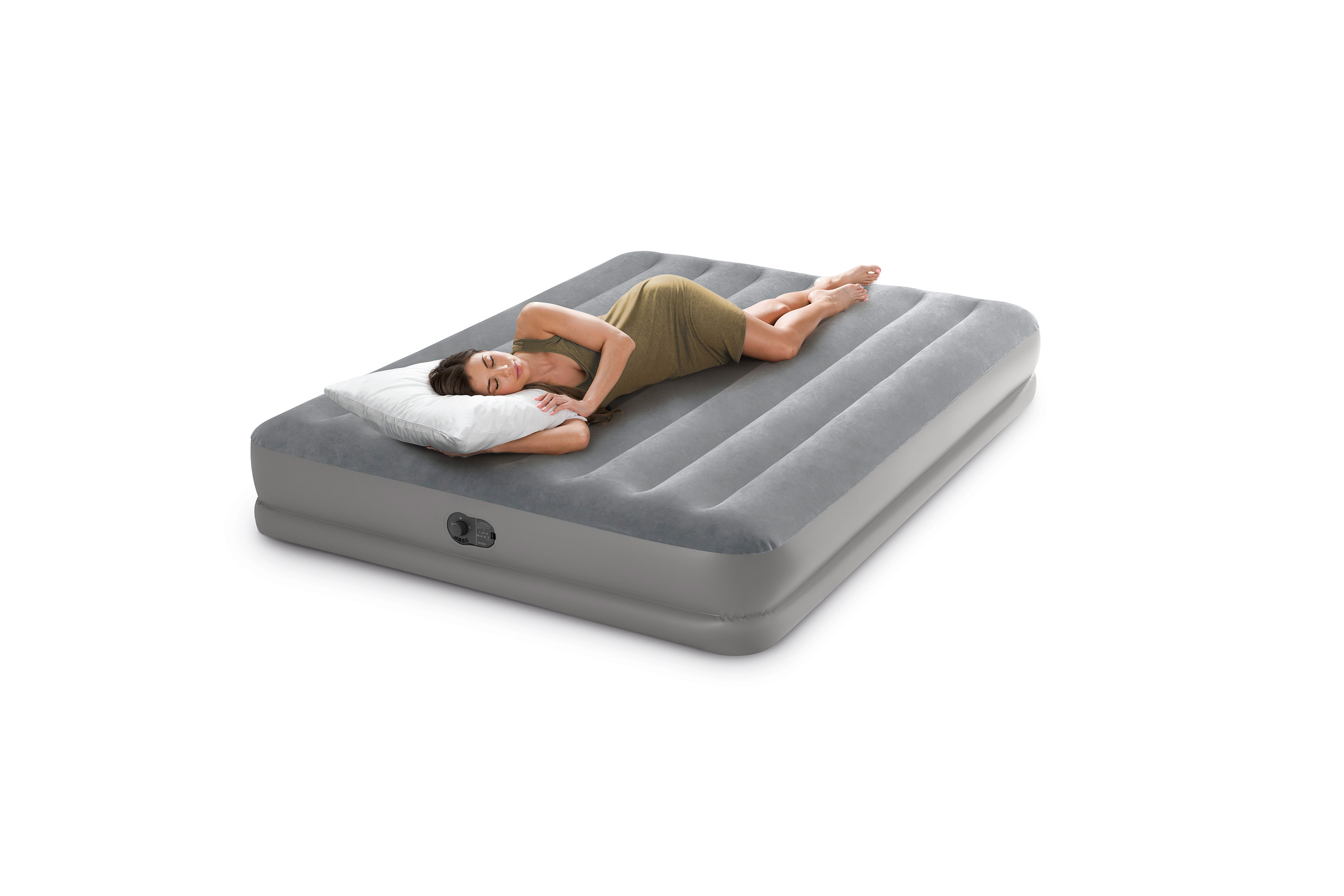 Una mujer duerme plácidamente en un colchón de aire gris grande con una almohada blanca.