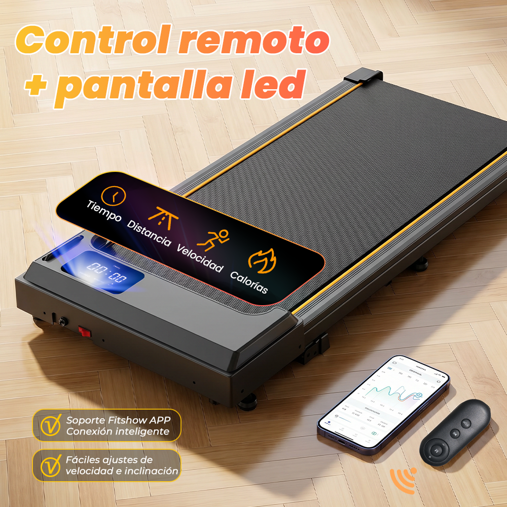 Caminadora gris en piso de madera con teléfono, control remoto y pantalla LED.