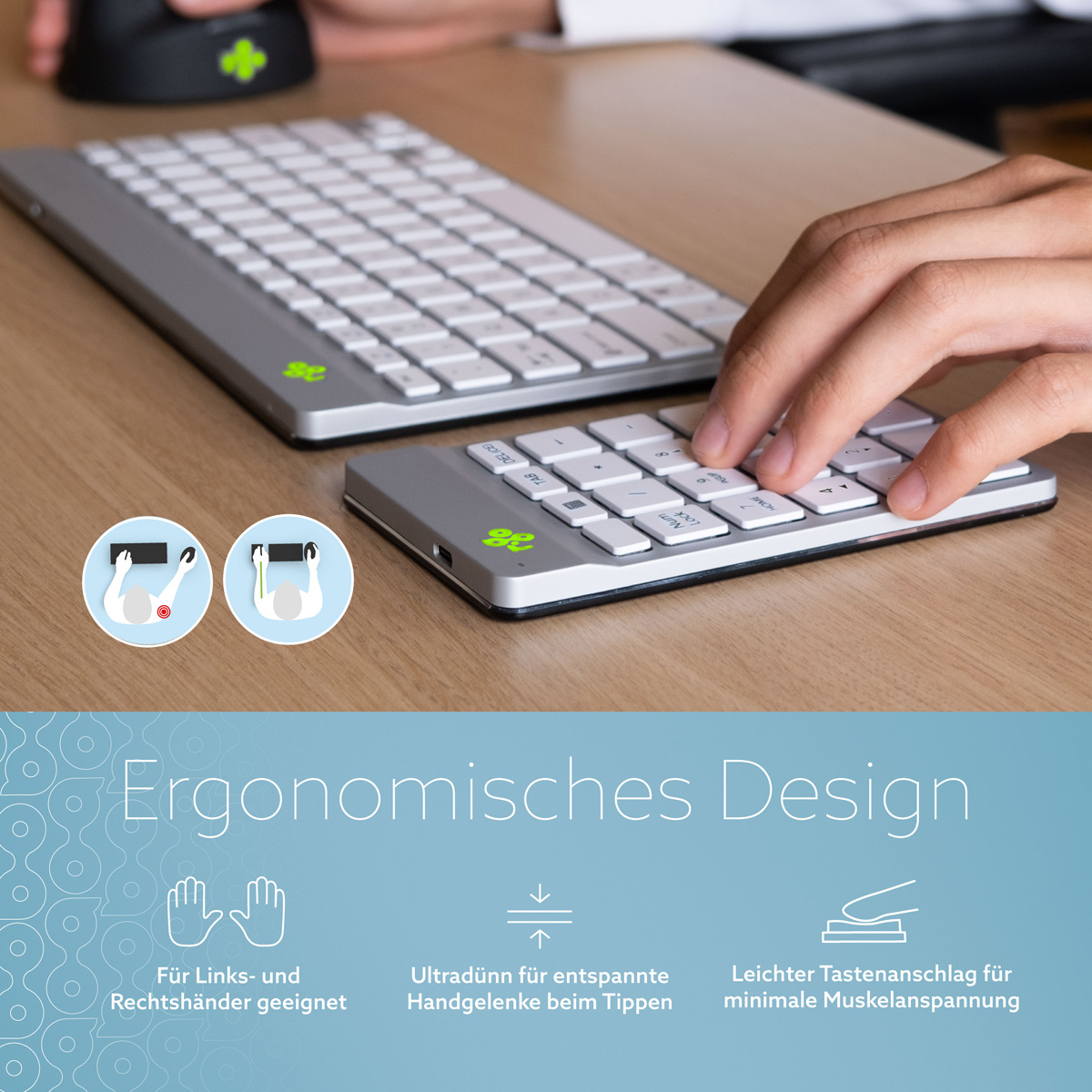 Tastiera ergonomica con tastierino numerico separato e mano sui tasti su una scrivania in legno.