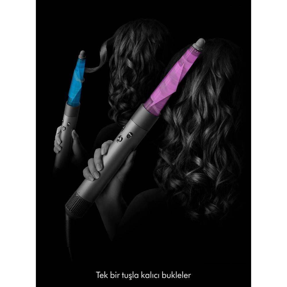 Donna che modella capelli neri con due arricciacapelli grigi che brillano di blu e viola su sfondo nero.