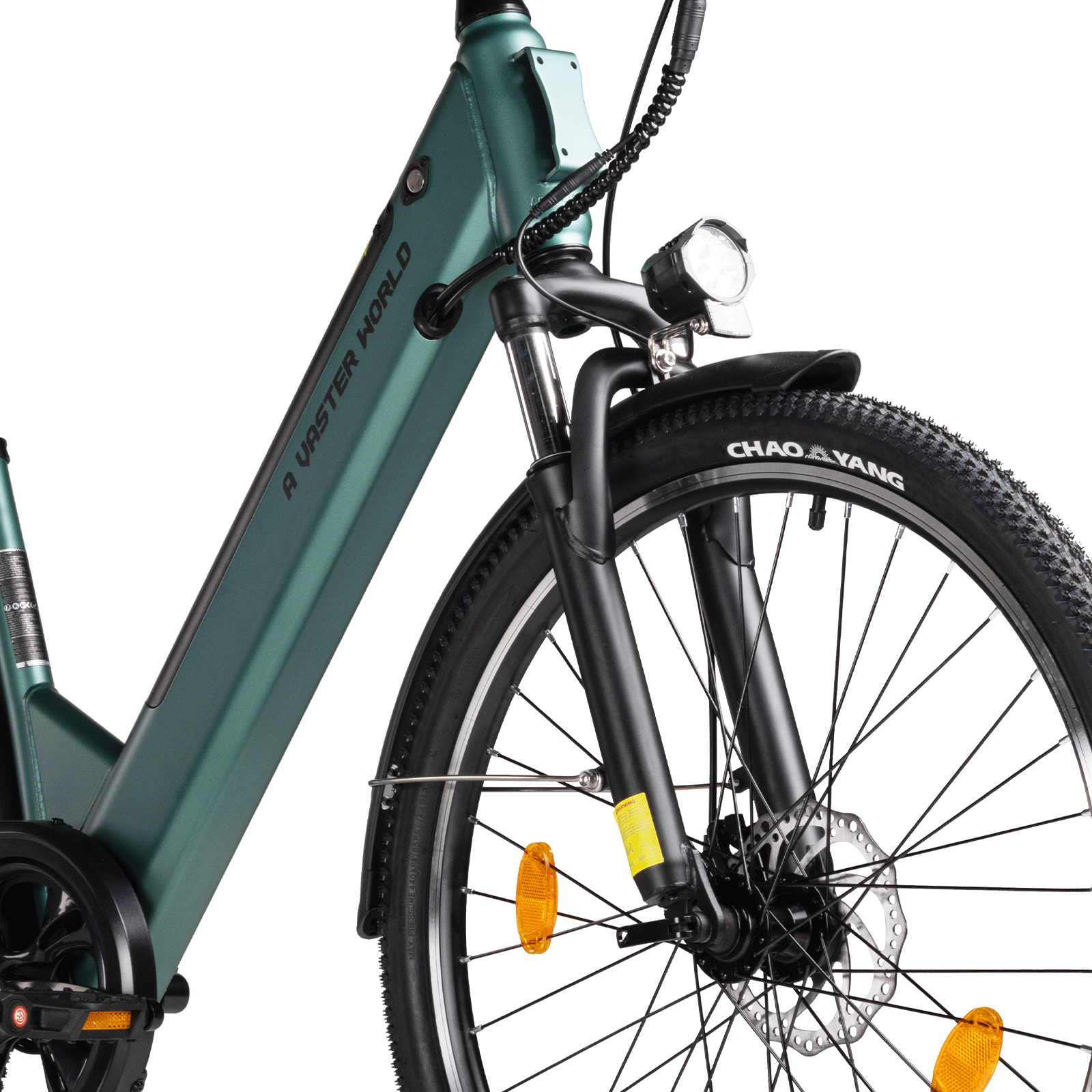 Primo piano della forcella anteriore di una e-bike verde con faro, ruota anteriore e sospensioni su sfondo bianco.
