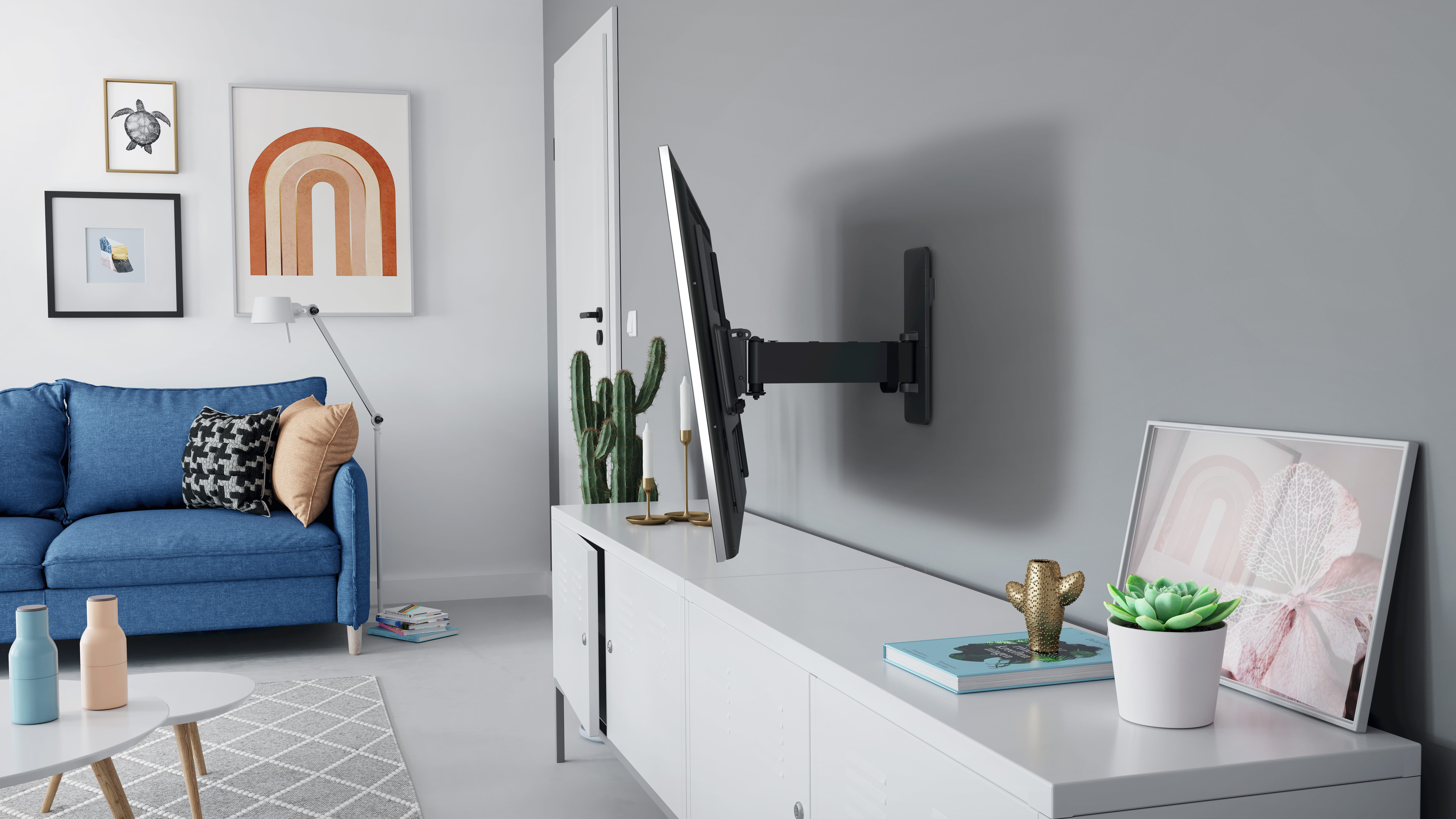 Un téléviseur mural au-dessus d'un meuble blanc dans un salon moderne avec un canapé bleu.