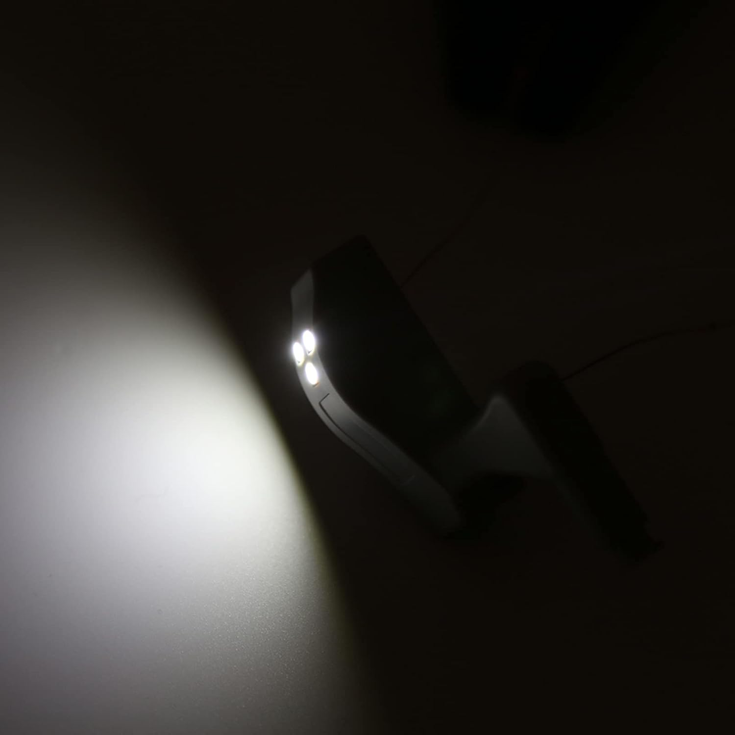 Eine Handlampe beleuchtet eine dunkle Wand.